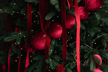 Decorating tree with bright Christmas baubles and ornaments.