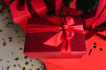 Red gifts under tree with glowing lights and festive ornaments.