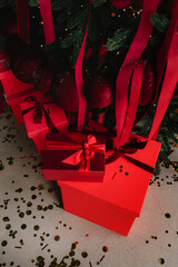 Festive Christmas tree with red gifts and sparkling decorations.