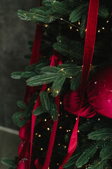 Christmas tree decorated with bright ornaments by girl hands.