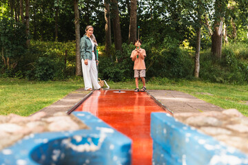 Mother and Son Playing on a Creative Minigolf Course