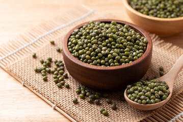 Mung bean seed in wooden bowl and spoon, Asian food ingredient