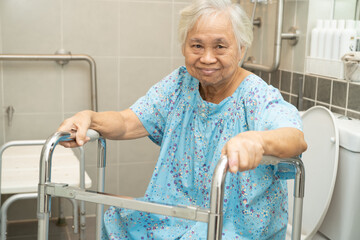Asian elderly woman patient use walker and toilet bathroom handle security in nursing hospital,...
