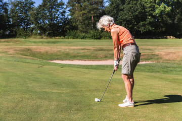 Senior Woman Concentrating on a Putt