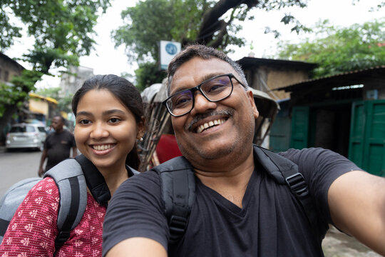 Self portrait of a middle aged father and his young daughter smiling