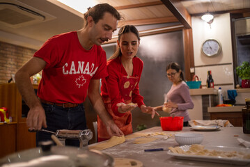 In a Warm Kitchen, Two People Work Together to Prepare Fresh Pasta
