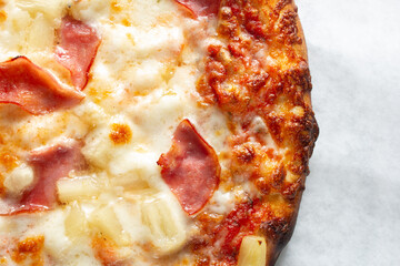 A top down view of a Hawaiian pizza.