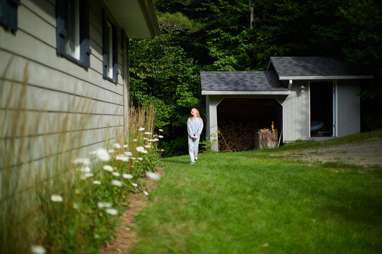 Girl Walking Beside Cottage and Shed