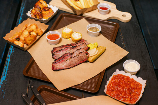 Delicious BBQ Feast With Fries, Sides, and Desserts at a restaurant
