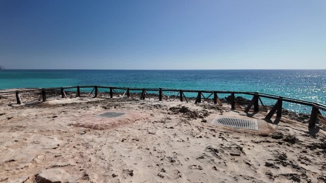 Blowhole on Mughsayl Beach close to Salalah in Dhofar, Oman, actively erupting a column of seawater mist towards a vibrant blue sky with the Indian Ocean in the background in dry season.