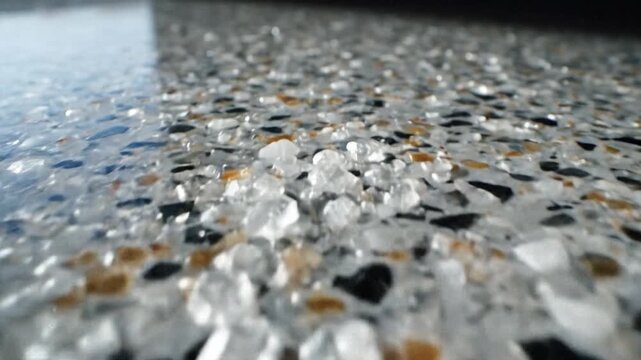 Closeup of a wet speckled surface with translucent aggregate