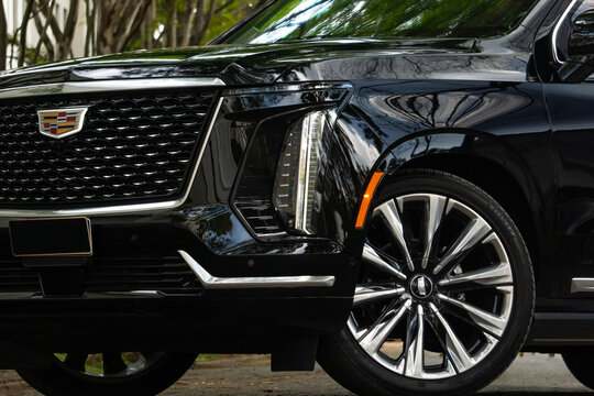 Black Cadillac Escalade front grille and headlight detail, Luxury SUV exterior closeup