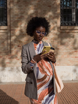 Pregnant woman using smartphone on the street 