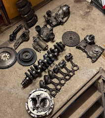 Various engine components are laid out on a garage workbench for inspection and repair