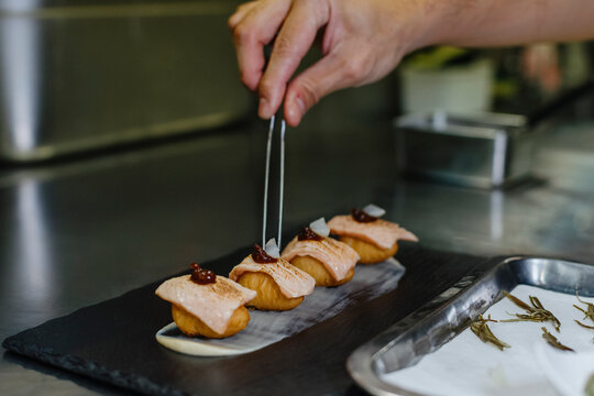 Chef dressing a potato ball sushi inside a restaurant kitchen