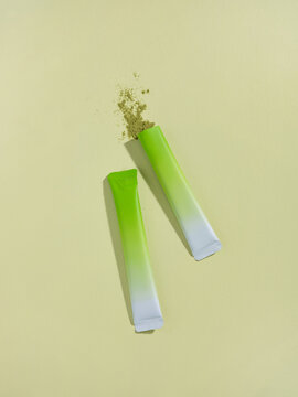Matcha packets with powder are shown on a light yellow