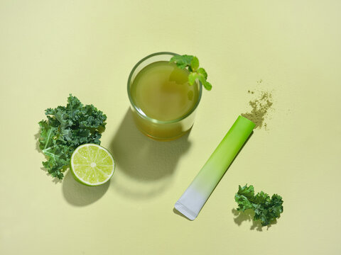 Freshly made green juice with kale, lime, and a packet of powder