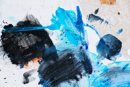 Blue and black paint stokes and splashes on white coated wood surface