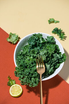 Fresh kale salad is ready to eat with a gold fork