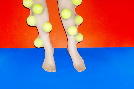 Person wearing tights filled with neon sport tennis balls with flash