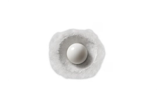 White pearl sphere resting in soft powder with transparent background