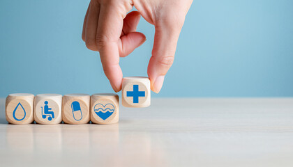 A hand places a health symbol block with other icons representing healthcare, wellness, and medical concepts against a blue background.