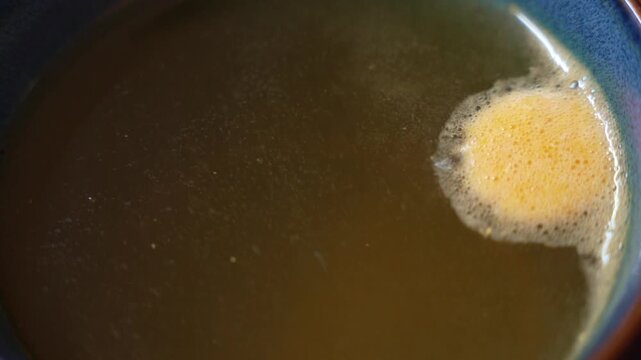 Effervescent vitamin tablet dissolving in water, producing bubbles and foam as nutrients disperse, symbolizing supplementation, hydration and daily health routine.