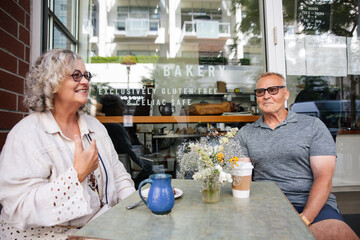 Cheerful seniors enjoying coffee outdoors