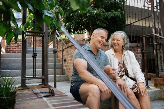 Smiling couple sitting on outdoor steps