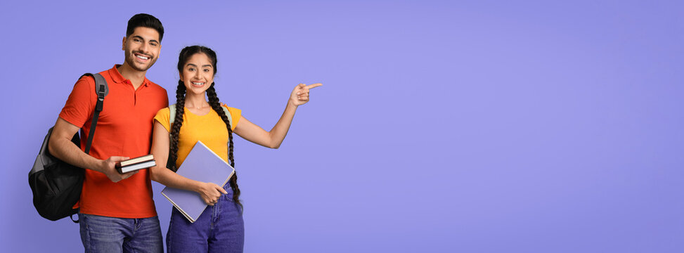 Two young students stand together, smiling brightly. The girl points towards the right, holding a notebook, while the boy holds two books. They seem happy and ready for the day.