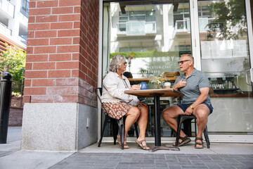 Couple enjoying coffee outside cafÃ©