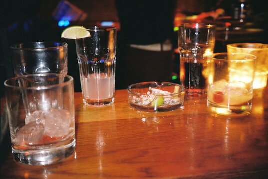 Empty Glasses and Cigarette Butts on a Bar Counter
