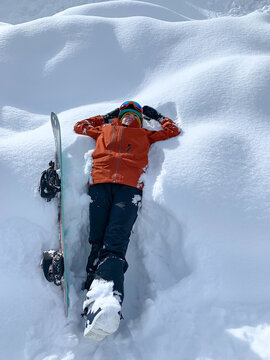 Snowboarder resting in fresh snow