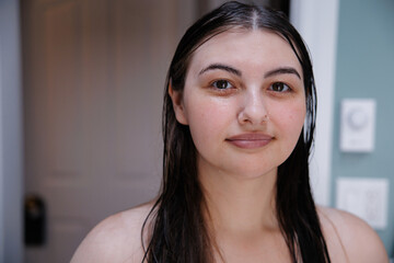 Young woman with wet hair posing confidently at home indoors