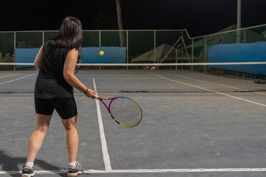 Playing Tennis at Night on an Outdoor Court