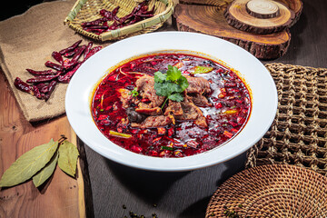 A bowl of Sichuan-style spicy beef soup with chili oil, mushrooms, and cilantro, surrounded by rustic spices and traditional Chinese elements.