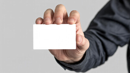 A person holding a blank white business card in their hand against a light gray background image view