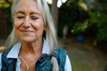 Smiling senior woman outdoors with closed eyes