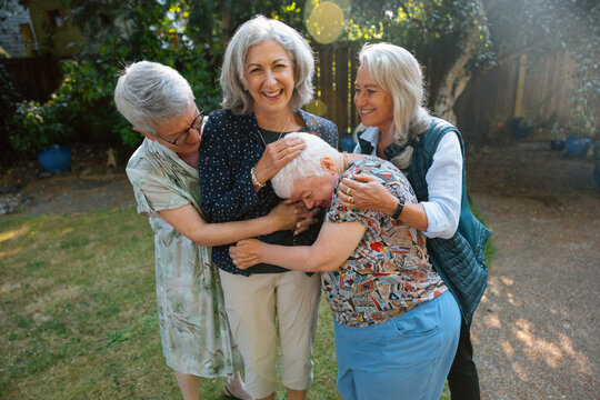 Happy seniors hug and share joyful moment in garden