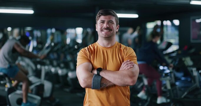 Face, fitness and happy man in gym with arms crossed, confidence and spin class instructor. Portrait, smile and indoor cycling coach in health club for exercise, professional trainer and pride