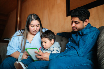 Parents Helping Toddler Draw in Notebook