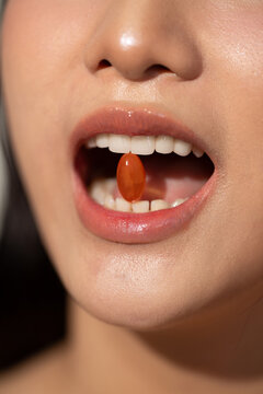 Woman holding a pill in her mouth