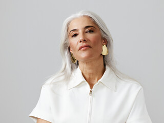 Elegant Woman With Silver Hair in Stylish Attire Poses Confidently