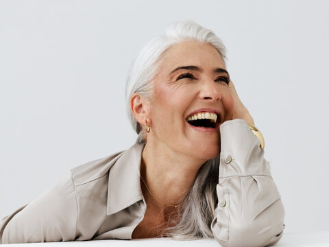 Joyful Woman Laughing With Silver Hair in a Light Setting
