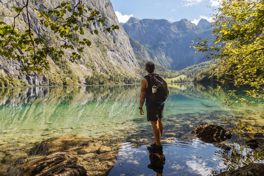Hiker Enjoying the Serene Beauty of a Mountain Lake in Summer