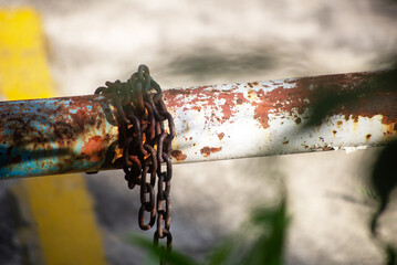 Rusty Chain on Old Metal Pipe in Nature