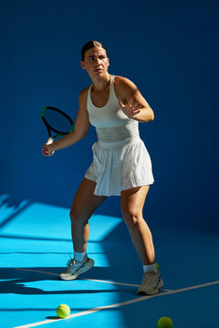 Tennis player prepares to hit a forehand on a blue court