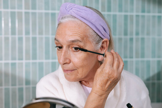 Senior woman applying mascara 