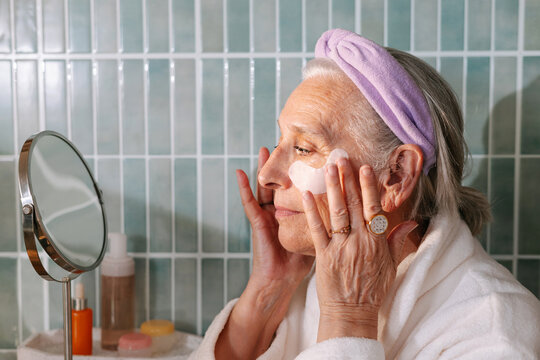 senior woman applying eye patches