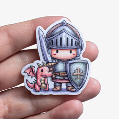 Cute cartoon knight with sword, shield, and dragon sticker held by fingers